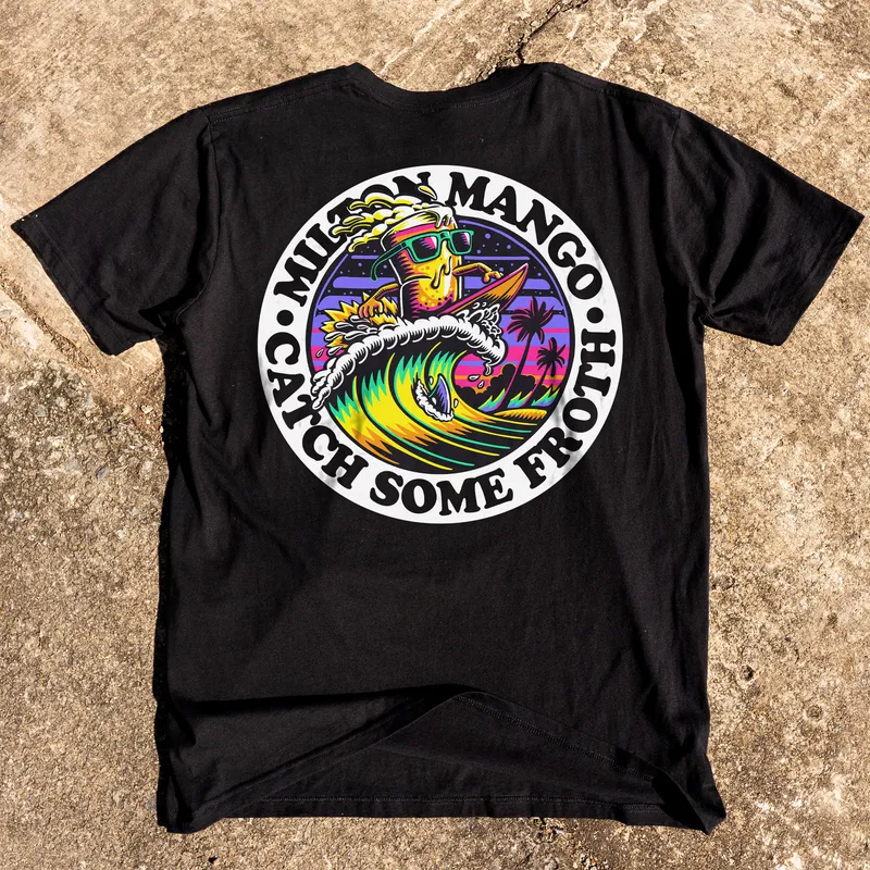 A black Milton Mango tee laid flat on concrete